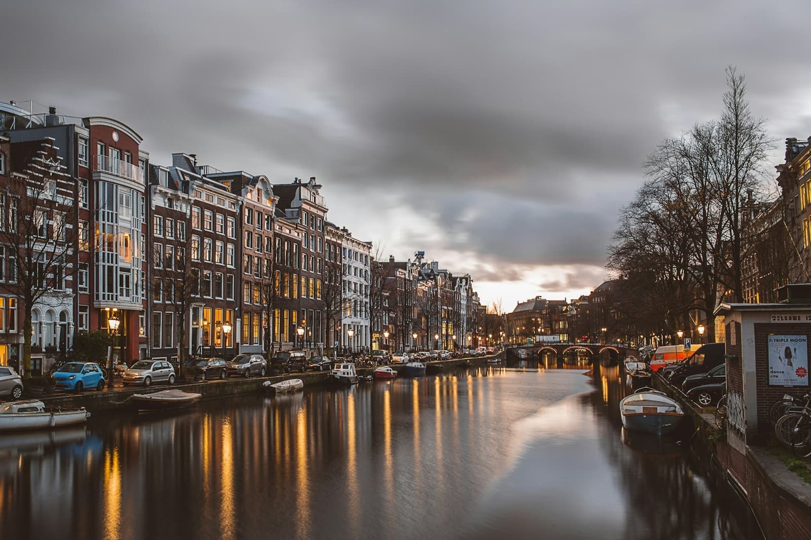 Canal lined with historic buildings in Amsterdam at dusk