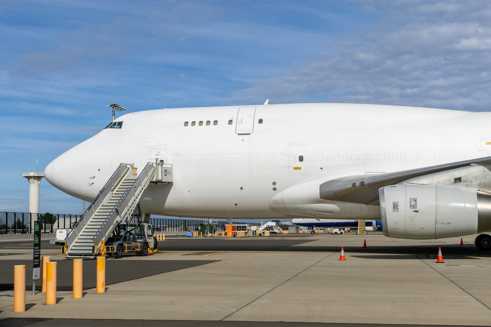 Wide-body cargo aircraft parked on the apron with boarding stairs
