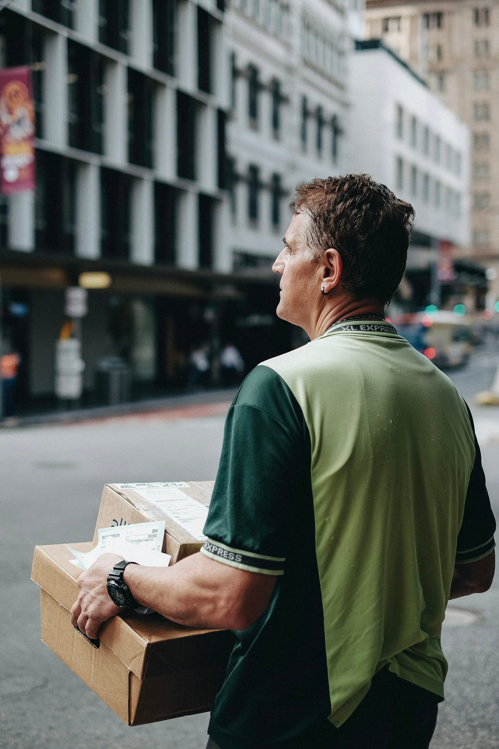 Person carrying cardboard boxes outdoors