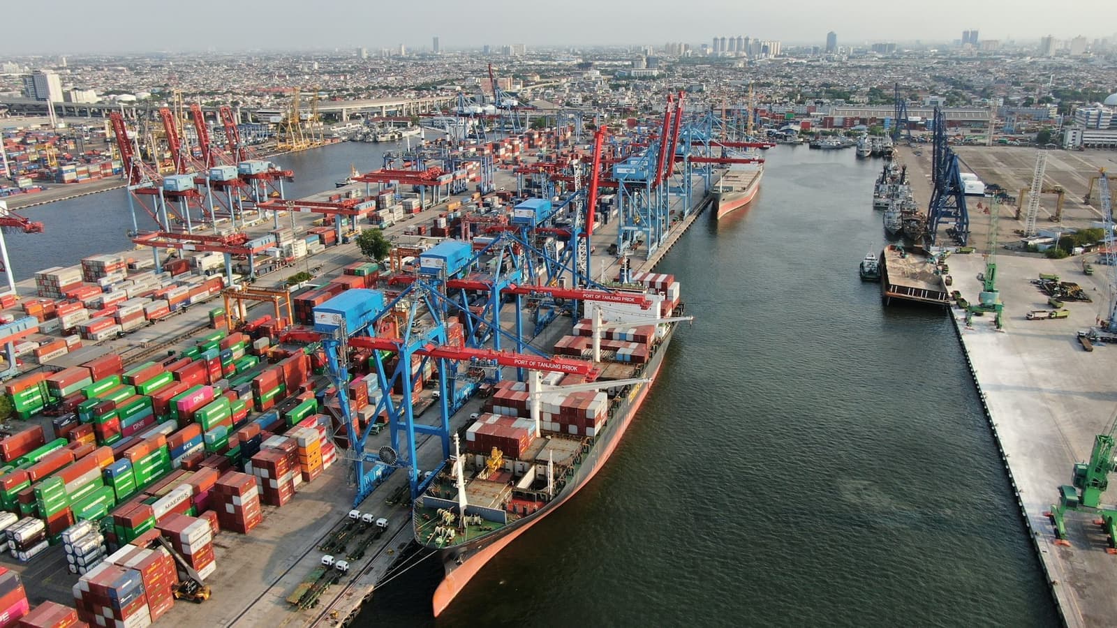 Busy shipping port with cranes and stacked cargo containers