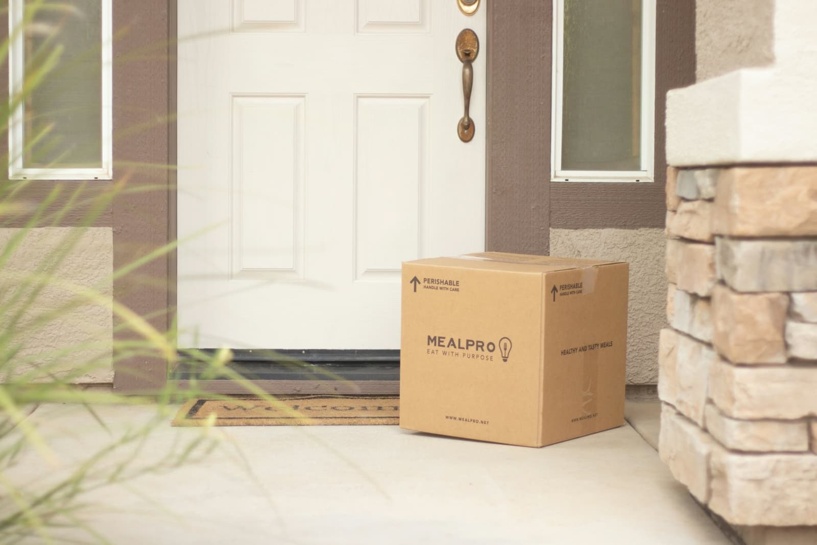 Cardboard parcel left beside a white front door